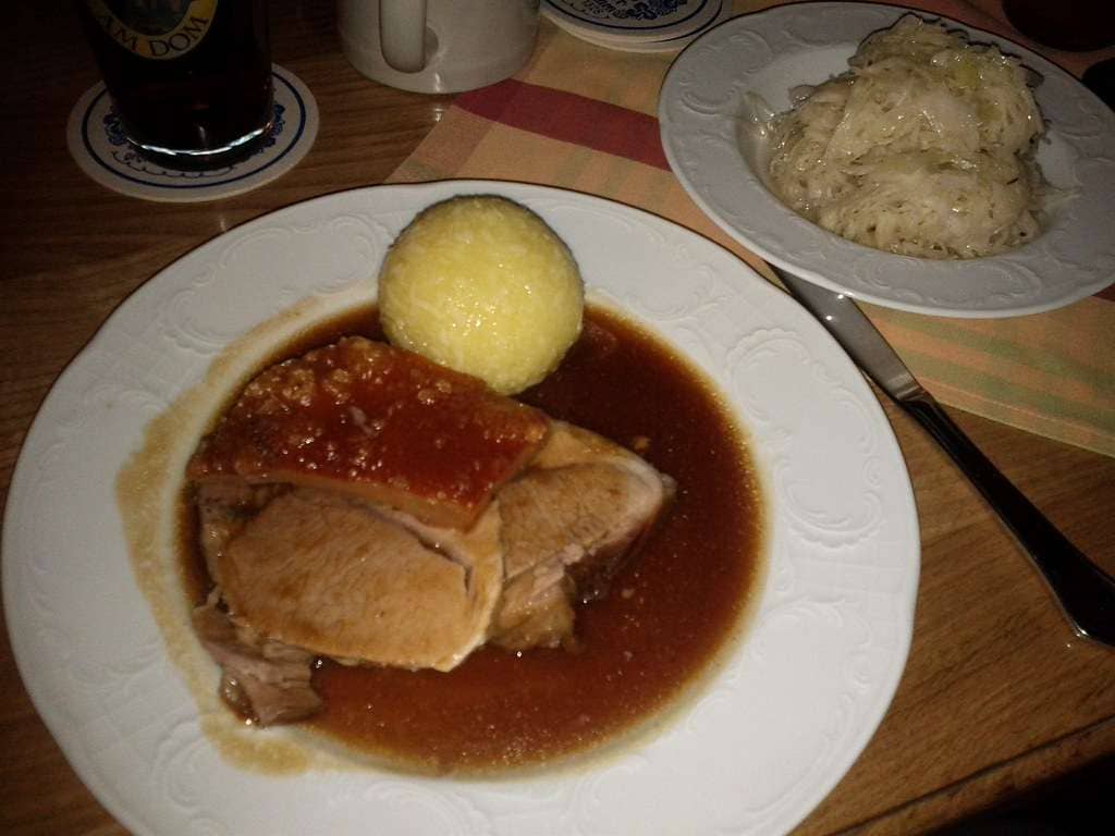 Traditionelles Bratl in der Rein 3 braten am teller mit kartoffelknödel und sauerkraut